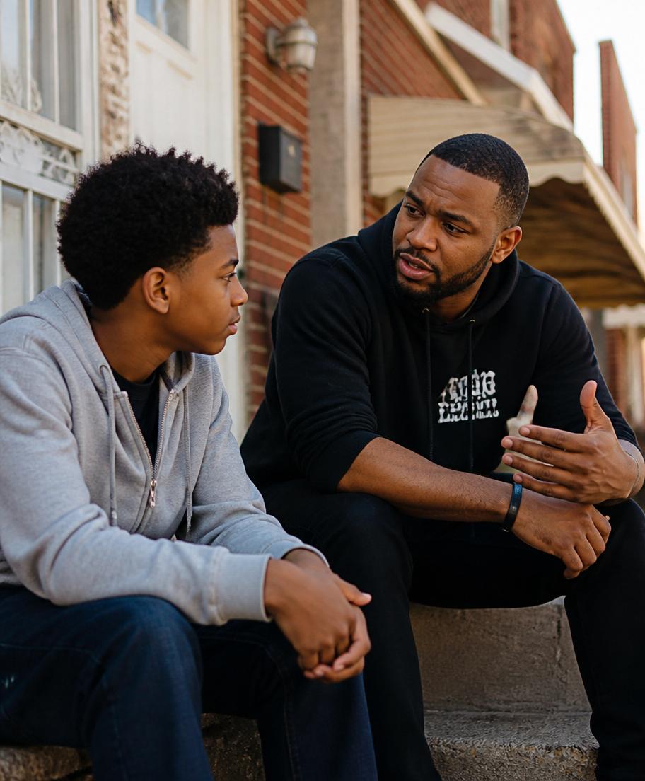 A mentor encouraging a teenager on the front steps of a neighborhood home.